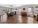 Open-concept living room with hardwood floors, neutral paint, and view of the backyard pool at 5388 Birchbend Loop, Oviedo, FL 32765