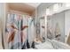 Bathroom featuring decorative shower curtain, large mirror, and updated lighting fixtures at 5395 Emerald Isle Drive # 1011, Orlando, FL 32812