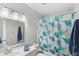 Bright bathroom with a modern vanity, well-lit mirror, and stylish shower curtain, creating a clean and inviting space at 5395 Emerald Isle Drive # 1011, Orlando, FL 32812