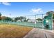 A fenced community tennis court available for residents surrounded by green space and trees at 5395 Emerald Isle Drive # 1011, Orlando, FL 32812