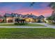Lovely exterior with meticulous landscaping and a paver driveway illuminated at dusk at 5640 Brookline Dr, Orlando, FL 32819