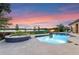 Inviting pool with spa overlooking a serene lake, against the backdrop of a beautiful sunset sky at 5640 Brookline Dr, Orlando, FL 32819