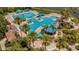 Aerial view of expansive community pool and kiddie pool with lush tropical landscaping at 5803 Cheshire Cove Ter, Orlando, FL 32829