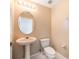 Cozy powder room with oval mirror, updated fixtures and a pedestal sink at 5803 Cheshire Cove Ter, Orlando, FL 32829