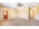 Neutral primary bedroom featuring ensuite bathroom, carpet flooring, and ceiling fan at 5803 Cheshire Cove Ter, Orlando, FL 32829
