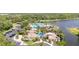 Aerial view of community pool and clubhouse surrounded by lush landscaping and a lake at 5803 Cheshire Cove Ter, Orlando, FL 32829