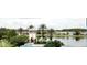 Scenic community entrance with manicured landscaping, a lake, and elegant signage at 5803 Cheshire Cove Ter, Orlando, FL 32829