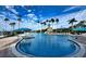Lush resort-style community pool surrounded by palm trees and sun loungers under a sunny sky at 5803 Cheshire Cove Ter, Orlando, FL 32829