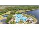 Aerial view of tropical oasis featuring pool and picnic cabanas by a lake at 5803 Cheshire Cove Ter, Orlando, FL 32829