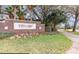 Community entrance sign with beautiful landscaping and lush green grass along a sidewalk path at 5803 Cheshire Cove Ter, Orlando, FL 32829