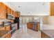 Charming open kitchen featuring wooden cabinetry, dark countertops, stainless steel appliances, and marble floors at 5803 Cheshire Cove Ter, Orlando, FL 32829