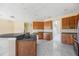 Spacious kitchen with wooden cabinets, dark countertops, stainless steel appliances, and marble floors at 5803 Cheshire Cove Ter, Orlando, FL 32829