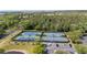 Overhead view of community tennis courts with blue and green playing surface in sunny, wooded locale at 5803 Cheshire Cove Ter, Orlando, FL 32829