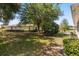 A spacious backyard features a lush lawn, mature trees, and partial fencing for privacy and security at 5962 Sw 98Th Street Rd, Ocala, FL 34476