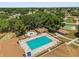 Aerial view of a community pool and adjacent amenities like a pavilion, tennis courts, and shuffleboard at 5962 Sw 98Th Street Rd, Ocala, FL 34476