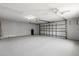 This clean garage offers ample space, with an overhead door, ceiling fan, and lighting fixtures at 5962 Sw 98Th Street Rd, Ocala, FL 34476
