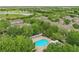 Aerial view of homes near golf course, lake, and community pool with trellis at 7130 Forty Banks Rd, Harmony, FL 34773