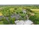 Aerial view featuring a golf course, parking, and nearby lake in the distance at 7130 Forty Banks Rd, Harmony, FL 34773