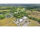 An aerial view displays a charming commercial area, a golf course, and lush green spaces, blending community and recreation at 7130 Forty Banks Rd, Harmony, FL 34773
