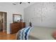 Comfortable bedroom showcasing wood flooring, a dresser, and wall decor at 7130 Forty Banks Rd, Harmony, FL 34773
