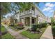 View of the townhome featuring manicured landscaping and a charming front porch at 7130 Forty Banks Rd, Harmony, FL 34773