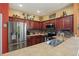 Well-lit kitchen featuring stainless steel appliances and rich wood cabinetry at 7130 Forty Banks Rd, Harmony, FL 34773