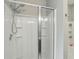 Detail of a walk-in shower, with a glass door, tiled walls, and dual showerheads at 7130 Forty Banks Rd, Harmony, FL 34773
