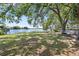 Lush backyard with mature trees, overlooking a picturesque lake, featuring a hammock for ultimate relaxation at 8616 Port Said St, Orlando, FL 32817
