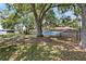 Backyard featuring a hammock, mature trees, and a fence along the lake, perfect for enjoying the outdoors at 8616 Port Said St, Orlando, FL 32817