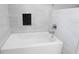 Stylish bathtub with tile surround and a niche for bath essentials in a modern bathroom at 8616 Port Said St, Orlando, FL 32817