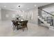 Open dining area with a modern chandelier, staircase, and views into the living room and fireplace at 8616 Port Said St, Orlando, FL 32817