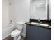 Bathroom features granite countertop, undermount sink, large mirror and tub with white tile surround at 8802 Positivity Dr, Kissimmee, FL 34747