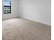 Bedroom features a neutral carpet, white walls, and well-lit window overlooking the outside at 8802 Positivity Dr, Kissimmee, FL 34747
