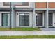 Townhome exterior featuring modern design elements, covered entryway, and tidy front lawn at 8802 Positivity Dr, Kissimmee, FL 34747