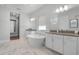 Bright bathroom featuring double vanity, soaking tub, and marble flooring at 9250 Neher St, Orlando, FL 32827