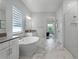 Bright bathroom featuring soaking tub, glass shower, and marble flooring at 9250 Neher St, Orlando, FL 32827