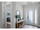 Bright entryway with a console table, decorative mirror, and frosted glass on the front door at 9250 Neher St, Orlando, FL 32827