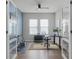 Bright home office with blue accent wall, wood floors, ceiling fan, and a bicycle on an indoor trainer at 9250 Neher St, Orlando, FL 32827