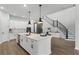 Contemporary kitchen island with a sink and bar seating complemented by a stylish staircase at 9250 Neher St, Orlando, FL 32827