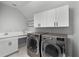 Well-organized laundry room with modern washer and dryer, white cabinets, and a sleek countertop at 9250 Neher St, Orlando, FL 32827
