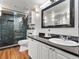 Modern bathroom featuring updated vanity with dark countertop, decorative mirror, and walk-in shower at 940 Douglas Ave # 118, Altamonte Springs, FL 32714