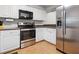 Well-equipped kitchen with white cabinets, stainless steel appliances, and tile flooring at 940 Douglas Ave # 118, Altamonte Springs, FL 32714