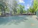 Outdoor tennis court surrounded by green trees and a fence at 940 Douglas Ave # 118, Altamonte Springs, FL 32714