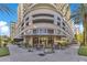 Exterior view of a luxury building with outdoor seating and a restaurant on the ground floor at 100 S Eola Dr # 1102, Orlando, FL 32801