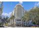 Stunning exterior view of a high-rise condominium building with rounded balconies and lush landscaping at 100 S Eola Dr # 1102, Orlando, FL 32801