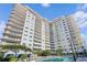 Upscale building exterior and community pool overlook tropical landscaping and lounge area at 100 S Eola Dr # 1102, Orlando, FL 32801