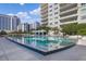 Reflections dance on the community pool, surrounded by lounge seating, manicured landscaping, and urban views at 100 S Eola Dr # 1102, Orlando, FL 32801
