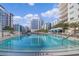 Beautiful swimming pool surrounded by lounge chairs and palm trees under sunny skies at 100 S Eola Dr # 1102, Orlando, FL 32801