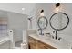 Bright bathroom with double sinks, shaker cabinets and a walk-in shower with white subway tile at 11209 Taeda Dr, Orlando, FL 32832
