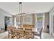 Elegant dining room with a large wooden table, neutral decor, and modern light fixture at 11209 Taeda Dr, Orlando, FL 32832
